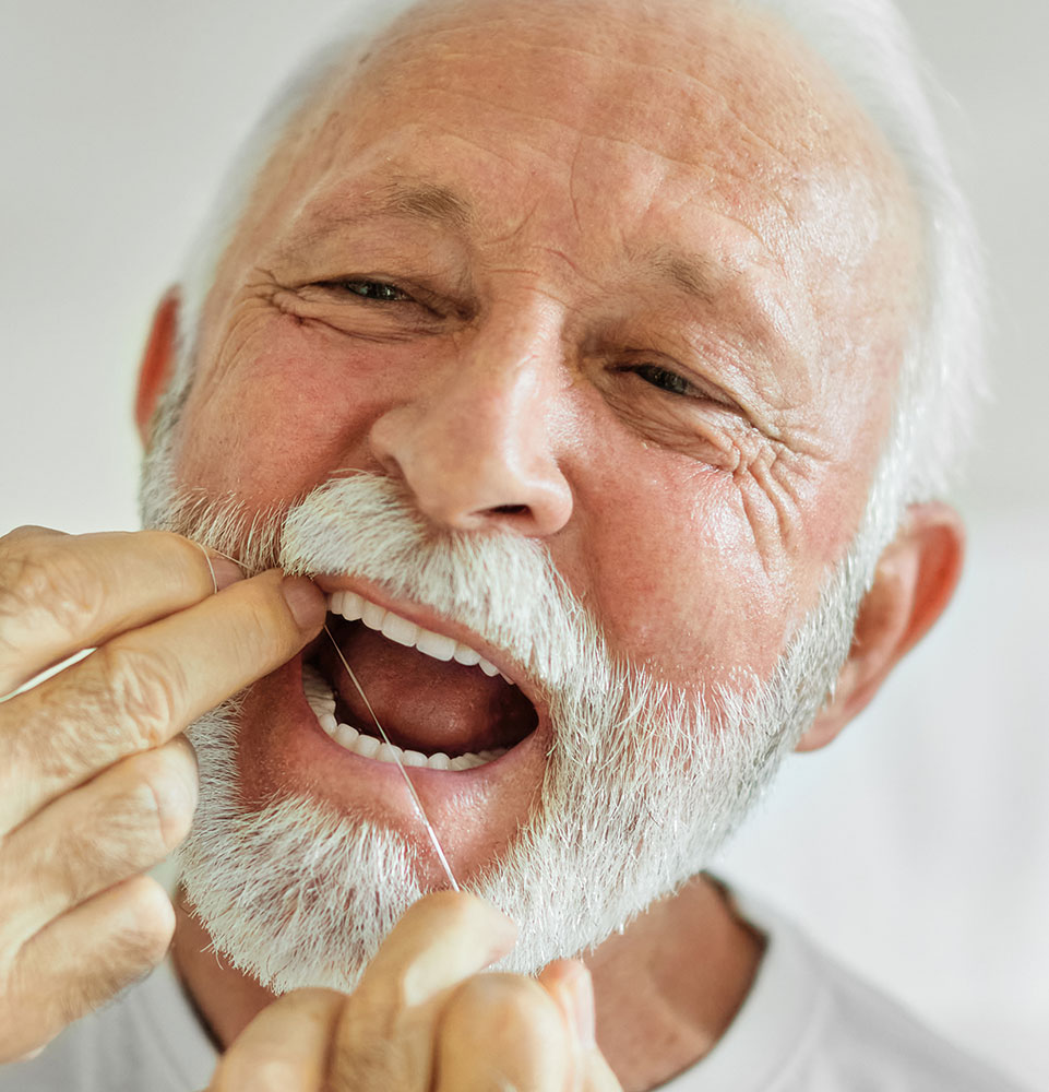 man flossing keeping teeth clean